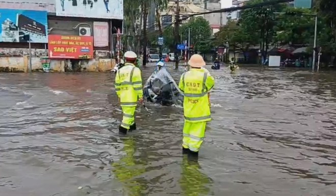 Cảnh sát giao thông hướng dẫn người dân tránh chỗ ngập sâu