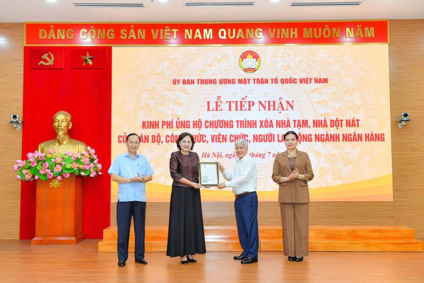 Đồng chí Đỗ Văn Chiến, Ủy viên Bộ Chính trị, Bí thư Trung ương Đảng, Chủ tịch Ủy ban Tung ương Mặt trận Tổ quốc Việt Nam tiếp nhận kinh phí ủng hộ do Thống đốc NHNN Nguyễn Thị Hồng đại diện trao tại buổi lễ tổ chức vào ngày 14/7/2025.
