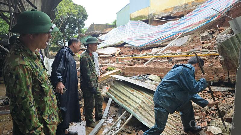 Các cán bộ, chiến sĩ phối hợp cùng lực lượng dân quân địa phương hỗ trợ khắc phục sự cố sập tường. Ảnh: Hiền Mai