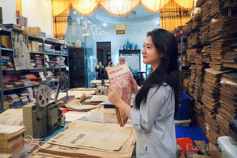 Phóng viên Minh Trang của Báo Công Thương cùng tờ Báo Thương nghiệp (tiền thân của Báo Công Thương) tại phòng sưu tầm của ông Nguyễn Phi Dũng.