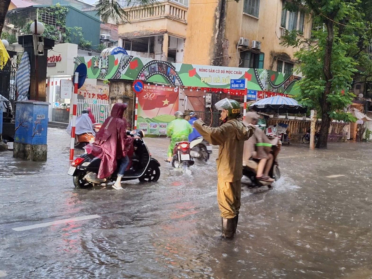 Công an phường Ba Đình phân luồng tại địa điểm ngập úng trên phố Quán Thánh. Ảnh: NS